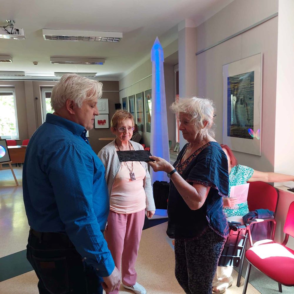 Przestrzen-dzwiek-kolory-6 Starszy mężczyzna prowadzi wykład dla uczestników Uniwersytetu Trzeciego Wieku