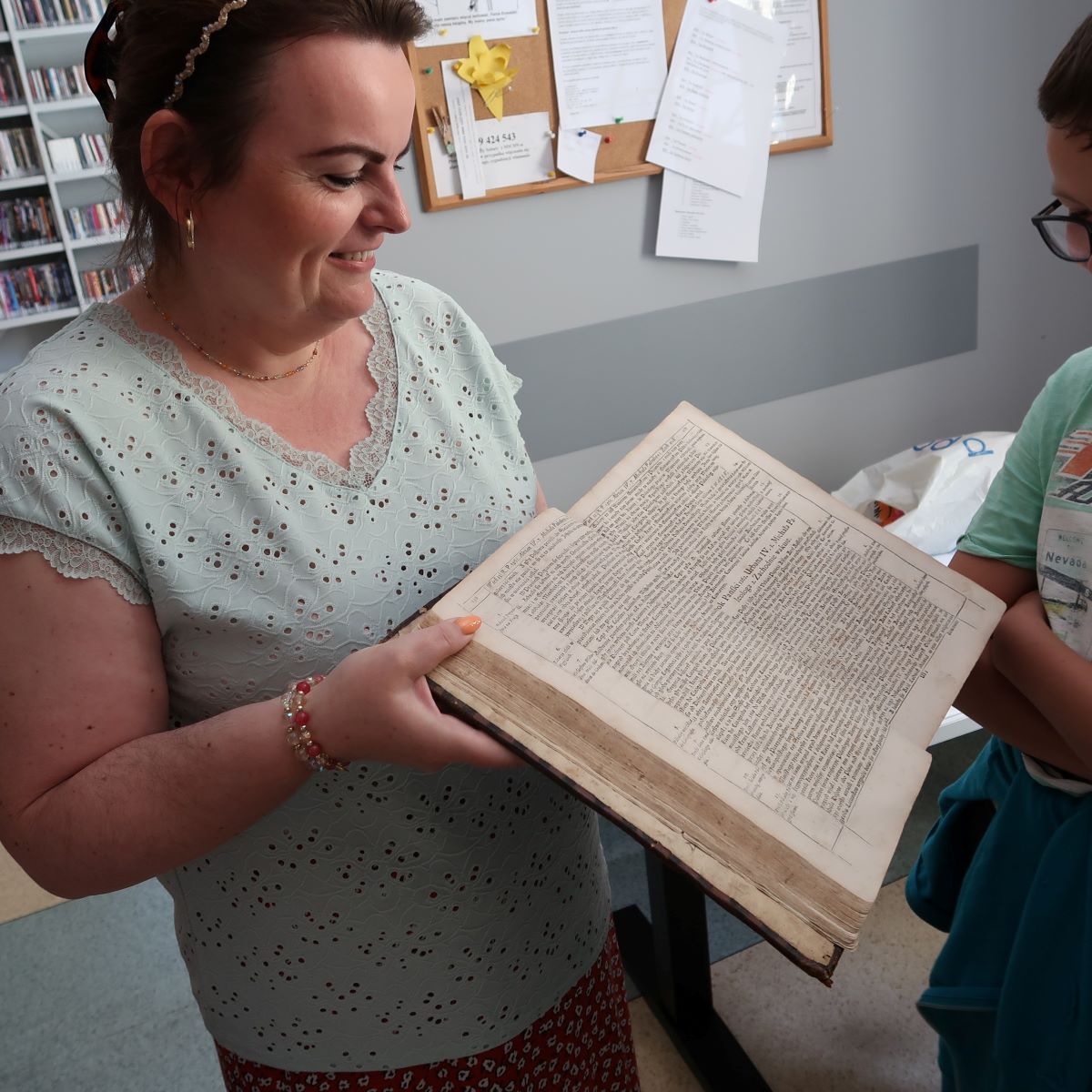 Bibliotekarka pokazuje dzieciom starodruk