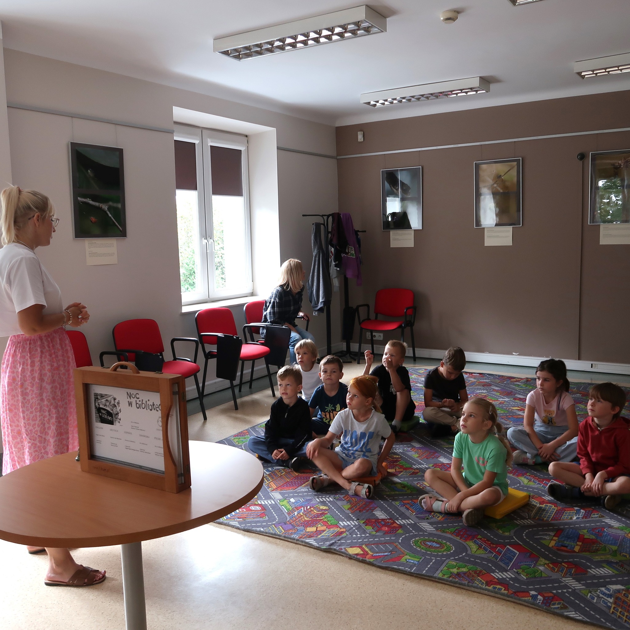 Dzieci siedząc na podłodze słuchają opowieści