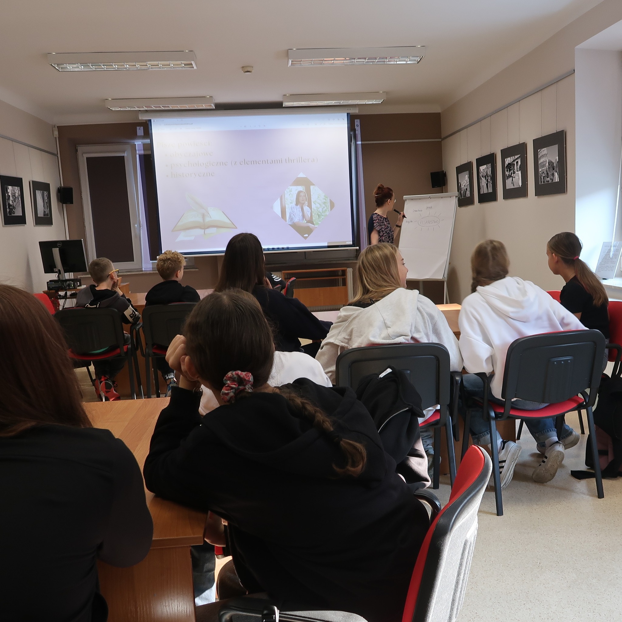 Uczestnicy zajęć obserwują rysunki robione przez wykładowcę na tablicy