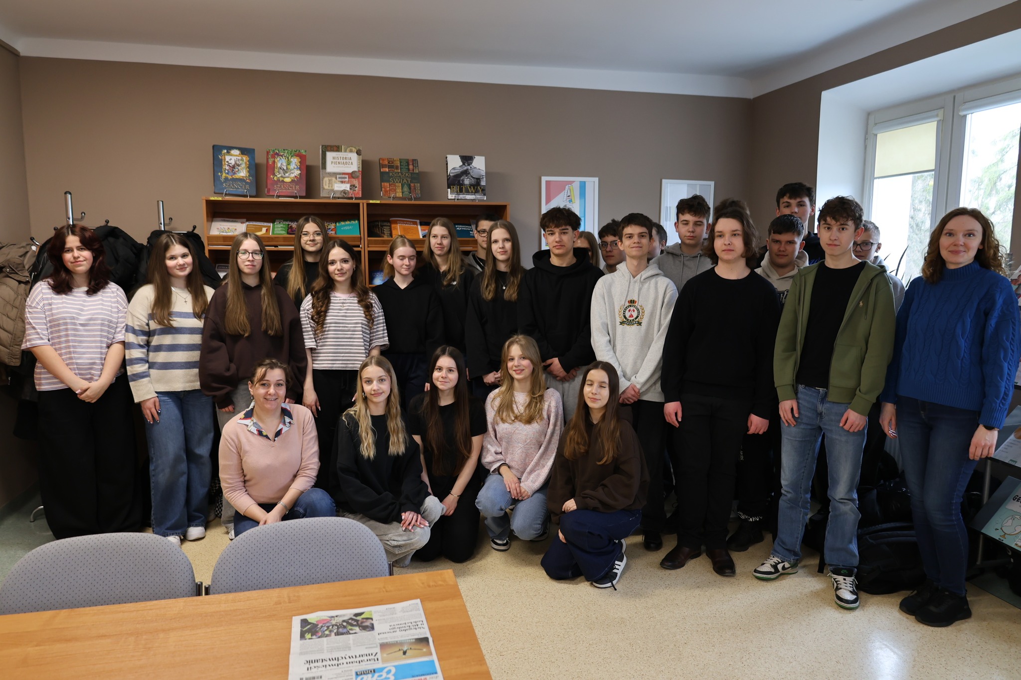 zbiorowe zdjęcie młodzieży na tle bibliotecznych półek
